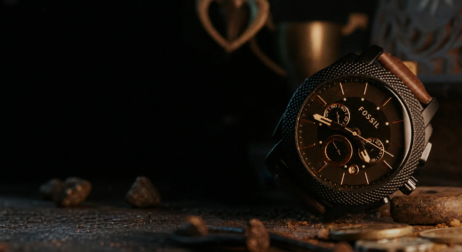 Schwarze Chronographenuhr in einer dunklen, staubigen Arbeitsumgebung